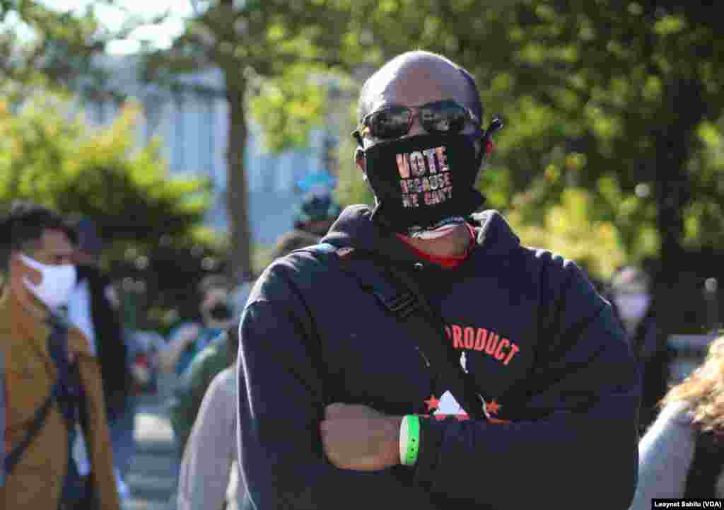 Um homem que participa na Marcha das Mulheres em Washington DC usa uma m&#225;scara facial dizendo &quot;Vota porque n&#243;s n&#227;o podemos&quot;. 17 out 2020