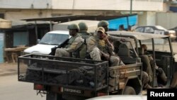 FILE - Soldiers of Ivory Coast's special forces drive through the city of Adiake, Ivory Coast, Feb. 7, 2017.