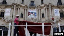 Workers do the final touches to one of the podiums near Havana's cathedral, that will be used during visit of Pope Francis, Cuba, Sept. 17, 2015. 