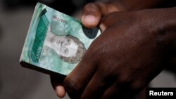 Seorang warga membawa setumpuk mata uang Venezuela, Bolivar, di Caracas (foto: ilustrasi). Tingkat inflasi diperkirakan mencapai 1 juta persen tahun ini.