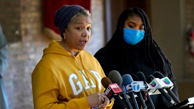 Cheri Warner, left, stands with her daughter, Brea, and speaks calling for the Chicago school district and teacher's union to focus on getting students back in the classroom Monday, Jan. 10, 2022, in Chicago. (AP Photo/Charles Rex Arbogast)