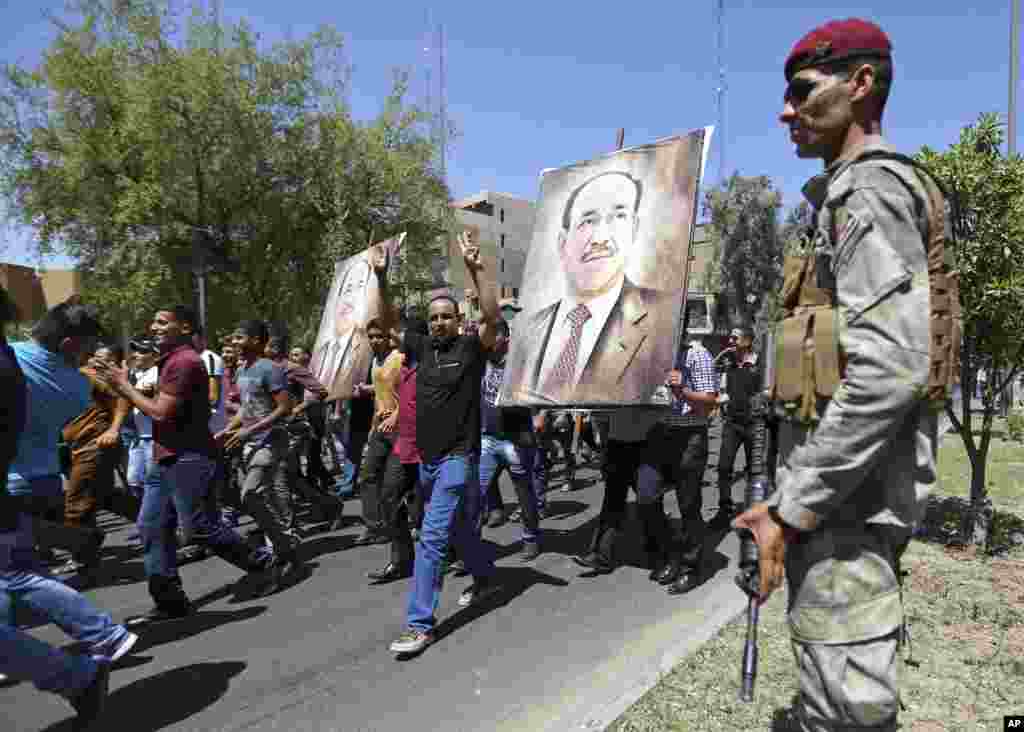 An Iraqi soldier stands guard amid tight security measures by Iraqi security forces during a pro-government demonstration to show support for embattled Prime Minister Nouri al-Maliki, in Baghdad, Iraq, Aug. 11, 2014. 