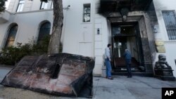 FILE - Two men look at the damage to the entrance of the Chinese Consulate in San Francisco on Thursday, Jan. 2, 2014.