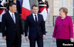French President Emmanuel Macron, German Chancellor Angela Merkel and Chinese President Xi Jinping leave following a meeting at the Elysee Palace in Paris, France, March 26, 2019.