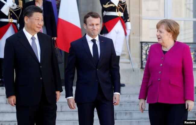 French President Emmanuel Macron, German Chancellor Angela Merkel and Chinese President Xi Jinping leave following a meeting at the Elysee Palace in Paris, France, March 26, 2019.