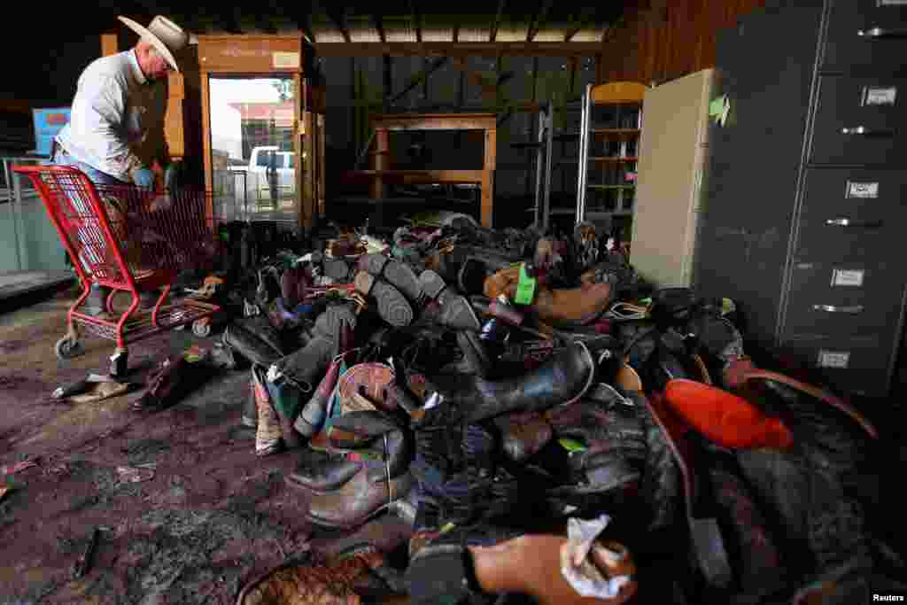 Tommy Phillips helps his son's small business, TNT Western Wear, as he sorts flood damaged cowboy boots in the aftermath of tropical storm Harvey, in Wharton, Texas, Sept. 6, 2017.