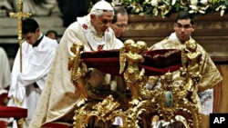 Pope Benedict XVI kneels in prayer as he celebrates Christmas Mass in St. Peter's Basilica at the Vatican, 24 Dec 2010