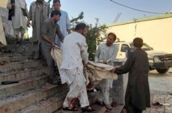 Warga membawa mayat korban serangan bunuh diri di masjid Syiah di Kunduz, Afghanistan, pada Jumat, 8 Oktober 2021.