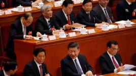 Chinese President Xi Jinping, center, talks to Li Zhanshu, a member of the Politburo Standing Committee, after casting their votes for an amendment to China's constitution that abolishes term limits on the presidency and enable Xi to rule indefinitely.