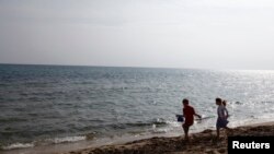 FILE - Children play at a beach in Hammamet, Tunisia, Feb. 19, 2013. 