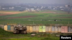An Israeli tank is positioned outside the northern Gaza Strip, March 13, 2014.