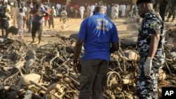 Nigerian police inspect the site of an explosion in Kano, Nigeria, Nov. 28, 2014. 