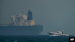 Un navire des garde-côtes émiratis autour d’un pétrolier au large de la côte de Fujairah, aux Émirats arabes unis, le lundi 13 mai 2019. (Photo AP / Jon Gambrell)