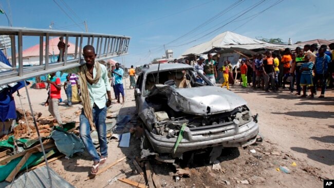 Un hombre pasa por un vehículo destrozado después de una explosión en un mercado en la capital, Mogadiscio, Somalia, el 19 de febrero de 2017.