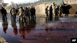 Afghan security forces inspect the site of a suicide attack at the gate of a Civil Order Police compound, in Kabul, Afghanistan, Feb. 1, 2016. (AP Photos/Rahmat Gul)