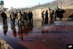 Afghan security forces inspect the site of a suicide attack at the gate of a Civil Order Police compound, in Kabul, Afghanistan, Feb. 1, 2016.
