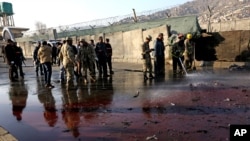 Afghan security forces inspect the site of a suicide attack at the gate of a Civil Order Police compound, in Kabul, Afghanistan, Feb. 1, 2016. 