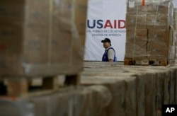 A man walks past boxes of USAID humanitarian aid at a warehouse at the Tienditas International Bridge on the outskirts of Cucuta, Colombia, Feb. 21, 2019, on the border with Venezuela.