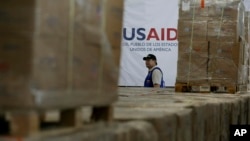 A man walks past boxes of USAID humanitarian aid at a warehouse at the Tienditas International Bridge on the outskirts of Cucuta, Colombia, Feb. 21, 2019, on the border with Venezuela. 