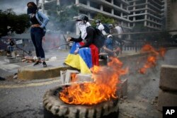 FILE - Masked anti-government demonstrators protest against the installation of a constitutional assembly in Caracas, Venezuela, Aug. 4, 2017.