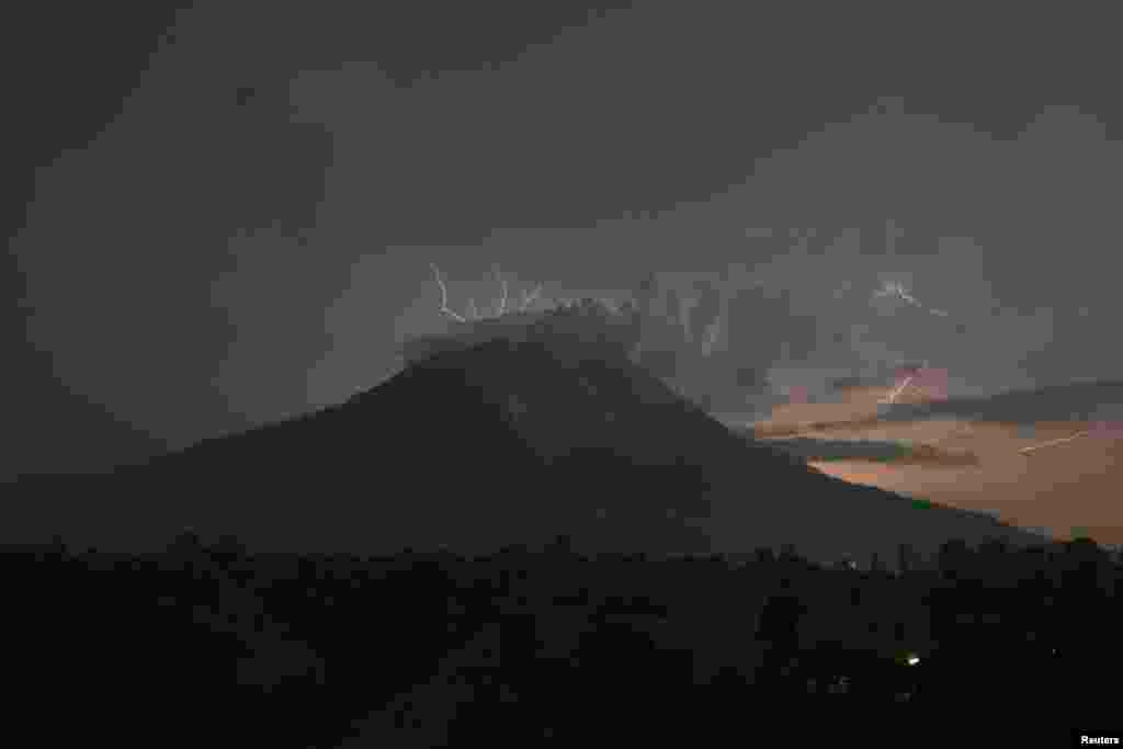 Lightning strikes as Mount Sinabung volcano spews ash and hot lava, at Simpang Empat village in Karo district, Indonesia&#39;s North Sumatra province, Sept. 18, 2013. 