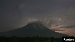 Petir menyambar saat Gunung Sinabung menyemburkan abu dan lava panas, di desa Simpang Empat, Karo, Sumatera Utara (18/9). 