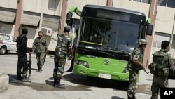 Syrian soldiers gather at the backyard of the municipality of Duma on the northeastern outskirts of the capital Damascus as rights groups said Syrian security forces killed six people and wounded dozens in raids in the northwest and around the capital, A