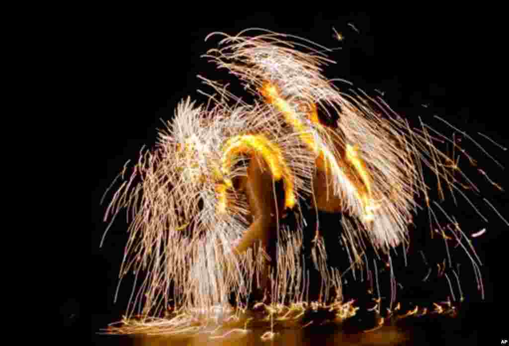 Romanians perform fire stunts during an event to mark Earth Day in Bucharest, Romania, Saturday, March 31, 2012.(AP Photo/Vadim Ghirda)