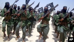 FILE - Al-Shabab fighters are seen marching with their weapons during exercises on the outskirts of Mogadishu, Somalia, Feb. 17, 2011. 