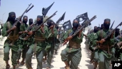 FILE - Al-Shabab fighters march with their weapons during military exercises on the outskirts of Mogadishu, Somalia, Feb. 17, 2011. Kenyan authorities said fighters carried out the cross border attack early Thursday on a police station at Hameey village, Sept. 22, 2016.