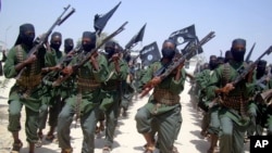 FILE - Al-Shabab fighters are seen marching with their weapons during exercises on the outskirts of Mogadishu, Somalia, Feb. 17, 2011.