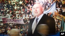 Parliamentary members walk past a poster of Kazakh President Nursultan Nazarbayev' after his annual state of the nation address, Astana, 2008 (FILE).