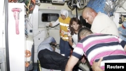 Wounded people are helped onto an ambulance after an explosion in the southeastern Turkish town of Gaziantep, August 20, 2012.