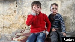 FILE - Injured boys react at a field hospital after airstrikes on the rebel held areas of Aleppo, Syria, Nov. 18, 2016. 