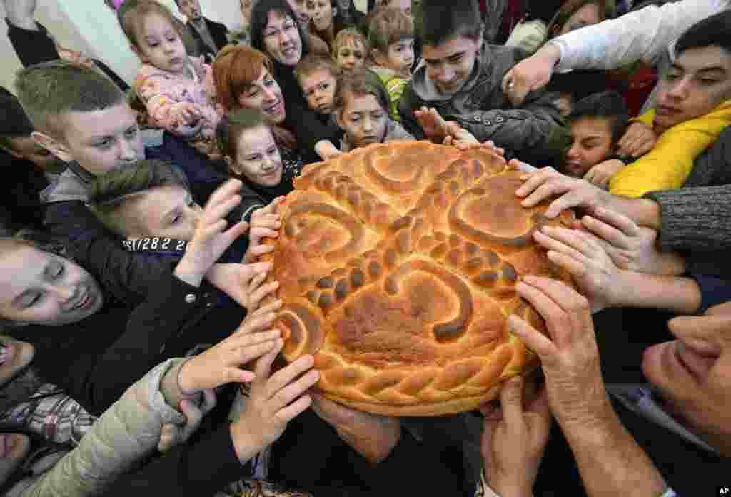 Bosnian Serb children prepare to break the traditional Christmas bread to mark Orthodox Christmas Day festivities in Bosnian town of Banja Luka, Bosnia, Jan. 8, 2018.