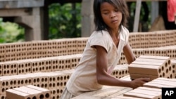 FILE PHOTO - A Cambodian girl prepares bricks to dry under the sunlight at a brick factory in Chheuteal village, Kandal province, some 27 kilometers (17 miles) north of Phnom Penh, Cambodia, Monday, May 2, 2011. 