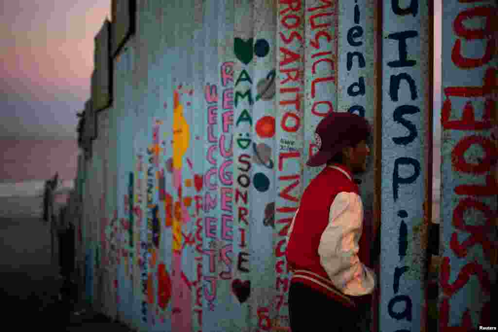 Angel, a 13-year-old migrant from Honduras, part of a caravan of thousands from Central America trying to reach the U.S., looks towards the United States past the border fence in Tijuana, Mexico, Nov. 15, 2018.