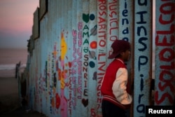 Angel, a 13-year-old migrant from Honduras, part of a caravan of thousands from Central America trying to reach the U.S., looks towards the United States past the border fence in Tijuana, Mexico, Nov. 15, 2018.