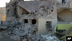 This photo provided by the Shafak Charity Organization, which has been authenticated based on its contents and other AP reporting, shows shows the badly damaged exterior of a medical facility dedicated to women after it was hit by four airstrikes that also killed two civilians in the northern Idlib province, Syria, Nov. 25, 2016.