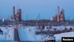 Sebuah mobil melaju di depan fasilitas pabrik pengolahan gas Amur yang sedang dibangun, bagian dari proyek Power Of Siberia Gazprom di luar kota timur jauh Svobodny, wilayah Amur, Rusia, 29 November 2019. (REUTERS/Maxim Shemetov)