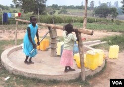 An orphan at the facility pumps water from a borehole that donors helped Mama Susan Tabia drill at the orphanage. (S.P. Apiku/VOA)