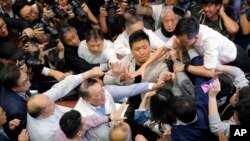 Pro-democracy and pro-Beijing lawmakers scuffle in the chamber of the Legislative Council in Hong Kong, May 11, 2019.