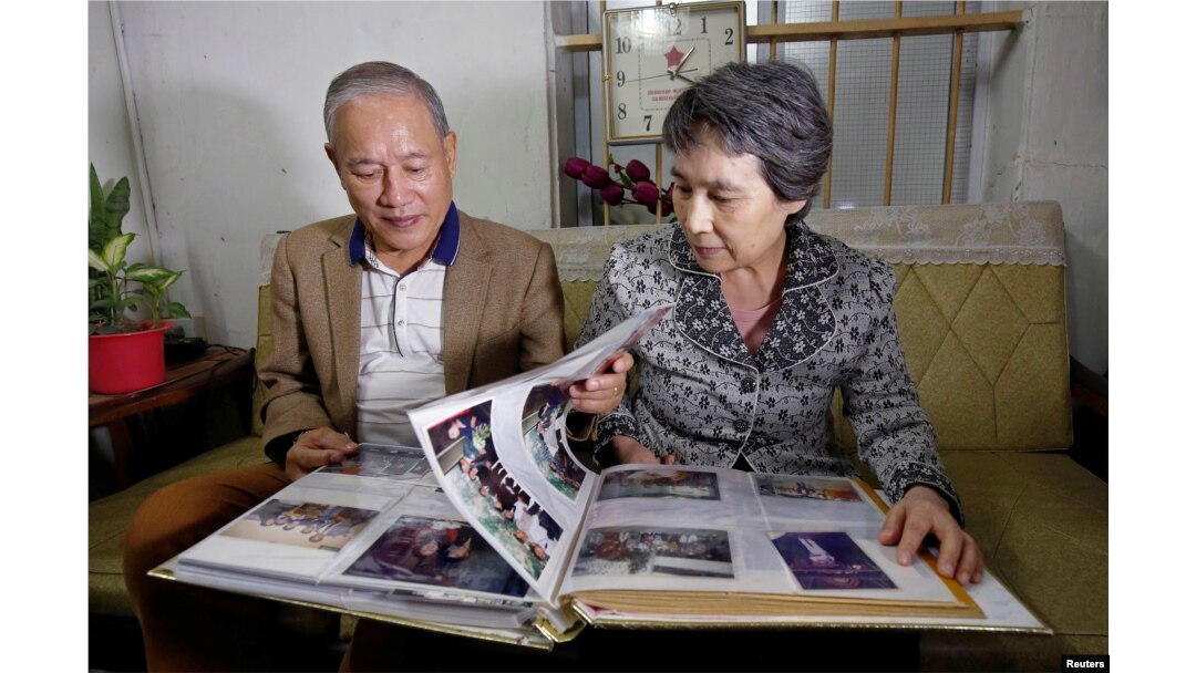 Mantan mahasiswa teknik kimia Vietnam,Pham Ngoc Canh, yang belajar di Korea Utara dan istrinya asal Korea Utara, Ri Yong Hui, melihat-lihat foto pesta pernikahan mereka di Hanoi, Vietnam,12 Februari 2019.