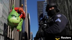 FILE - A member of the New York Police Department's Counterterrorism Bureau guard the parade route as a Grinch balloon floats by during the Macy's Thanksgiving Day Parade in Manhattan, New York, Nov. 23, 2017.