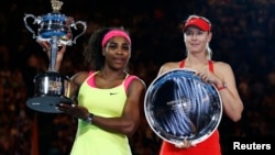 Serena Williams (L) of the United States and Maria Sharapova of Russia pose with their trophies after their women's singles final match at the Australian Open 2015 tennis tournament in Melbourne January 31, 2015. 