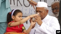 A girl offers lemon juice to social activist Anna Hazare after he called off his hunger strike during a campaign against corruption in New Delhi, April 9, 2011.