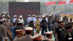 Opposition leader Aung San Suu Kyi, in yellow leaves after attending Burma’s 68th anniversary celebrations of Armed Forces Day, in Naypyidaw, March 27, 2013. 