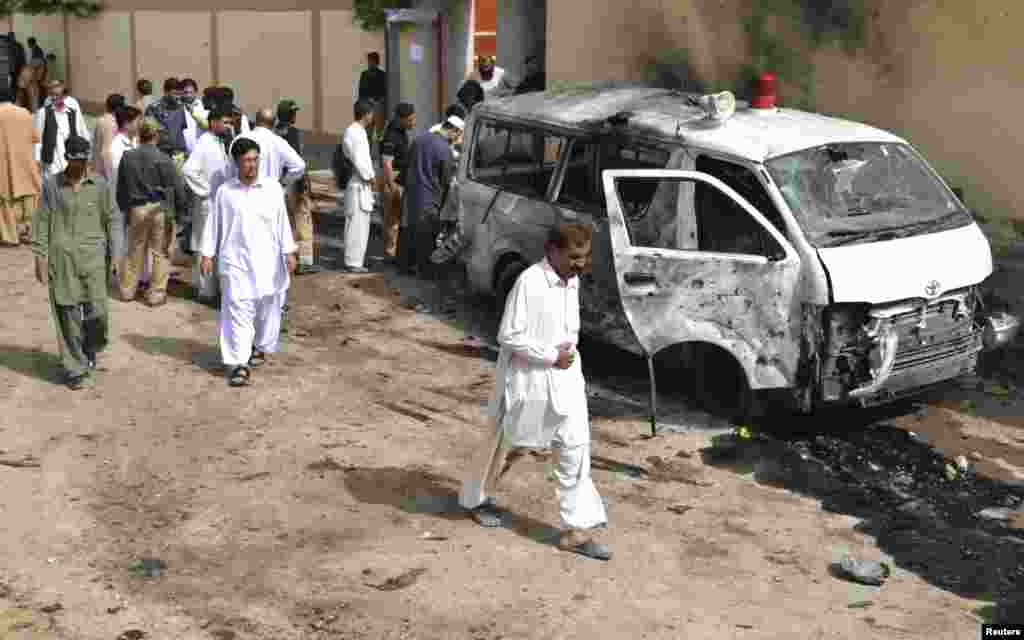 Security officials gather at the site of a bomb attack in Quetta, Pakistan, August 8, 2013. 