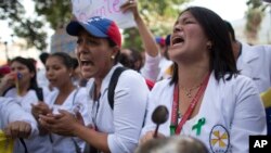 Nurses shout slogans during a protest against the government of President Nicolas Maduro, in Caracas, Venezuela, Aug. 16, 2018. The nurses were confronted by a phalanx of police officers that prevented them from marching toward Miraflores Presidential Palace several miles away.