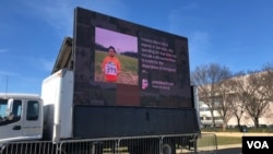 Ekran koji prikazuje mlade imigrante u blizini Kapitol Hila - deo performansa kojim se jača pritisak na Kongres da usvoji akt o mladim imigrantima